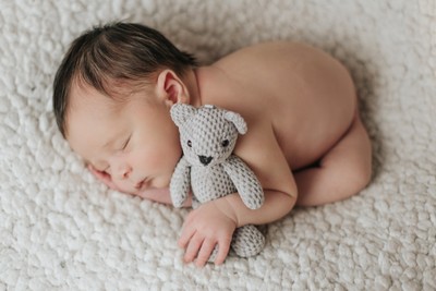 Sessão newborn, bebé recém-nascido em pose delicada com acessórios artesanais